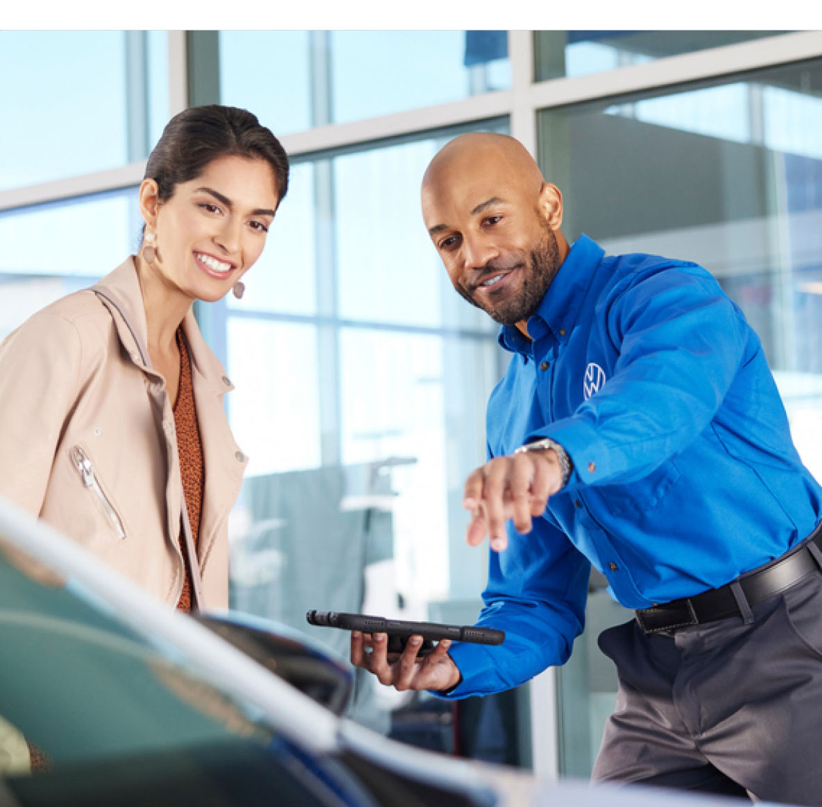 Volkswagen advisor showing vehicle features to a customer inside the dealership