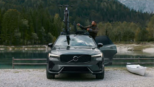 Volvo XC60 parked by lake with bike mounted on roof rack
