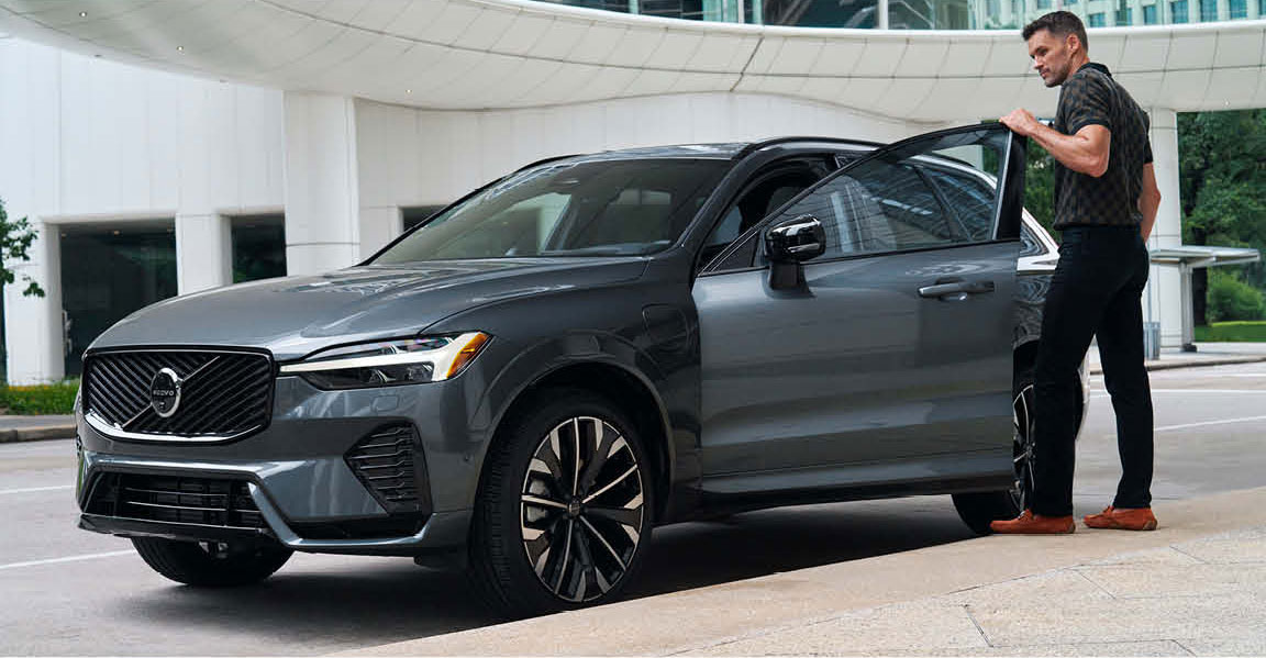 Man stepping out of Volvo XC60 parked in modern urban setting