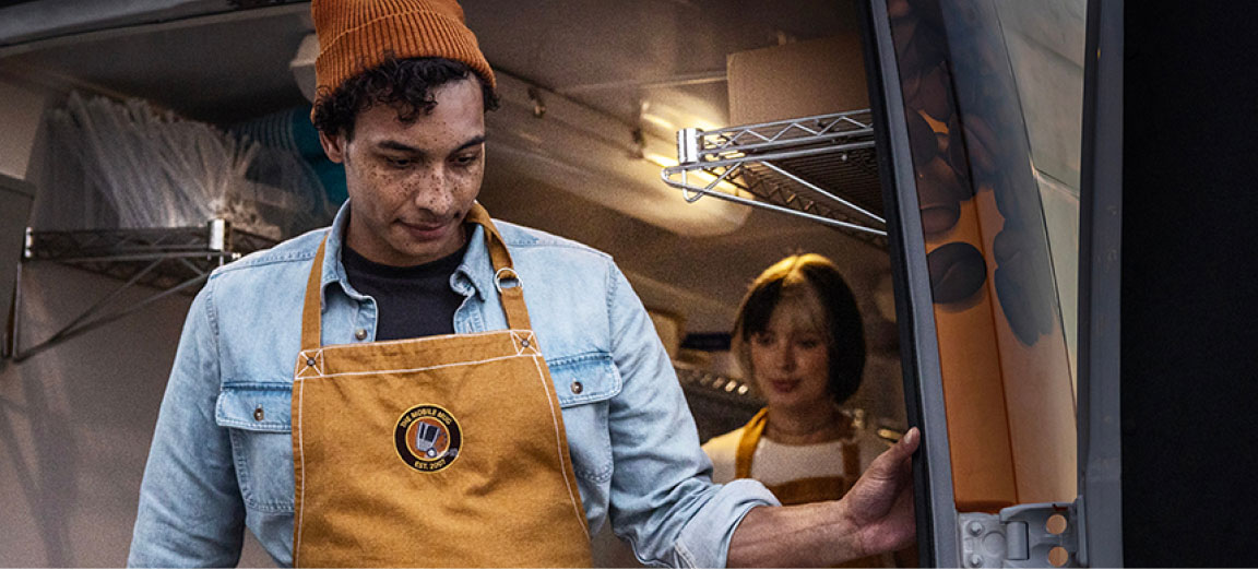 food truck operator working inside a mobile café van equipped for food and beverage service
