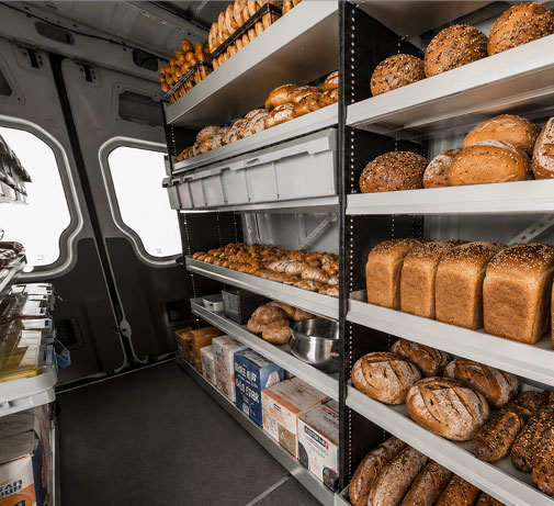 organized bakery delivery van interior with shelves stocked with fresh bread and baked goods