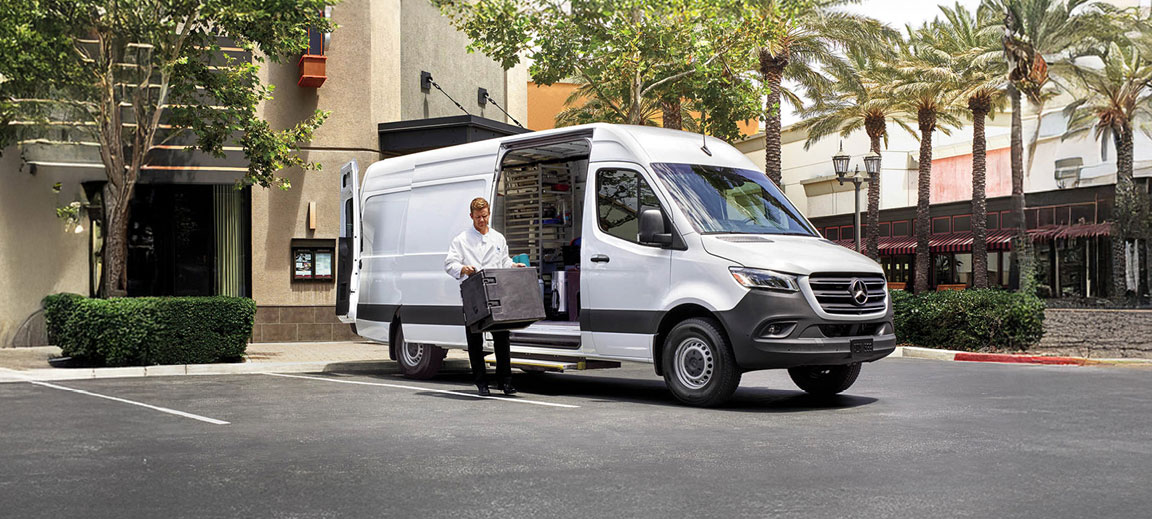 Mercedes-Benz Sprinter cargo van parked curbside while driver unloads products for local business deliveries