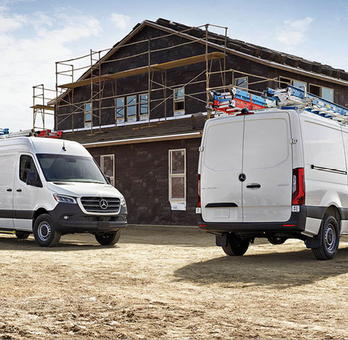 Mercedes-Benz Sprinter work vans parked at a home construction project with contractor equipment