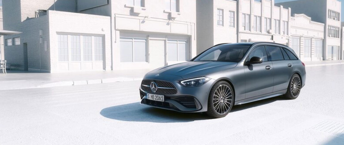 Mercedes-Benz C-Class wagon parked on a bright city street with contemporary architecture