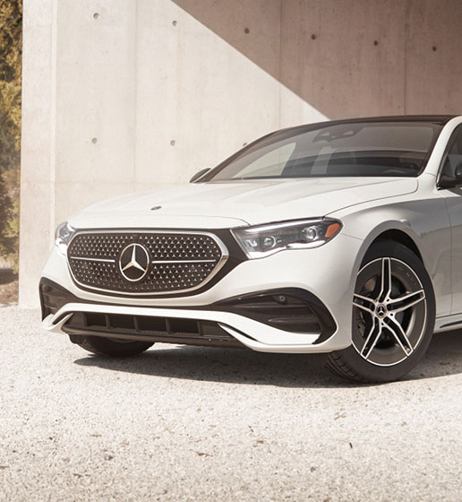 close-up of Mercedes-Benz sedan front fascia featuring diamond-pattern grille and LED headlights