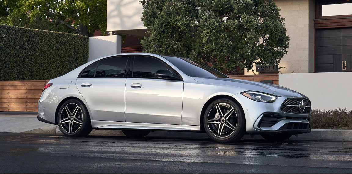 silver Mercedes-Benz C-Class sedan parked in front of a modern upscale home