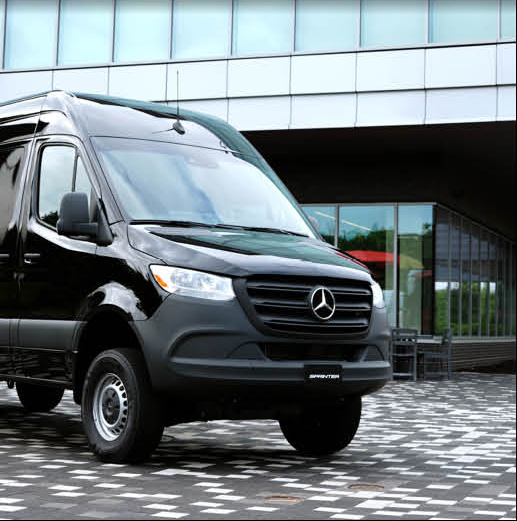 Black Mercedes-Benz Sprinter van parked outside a commercial building