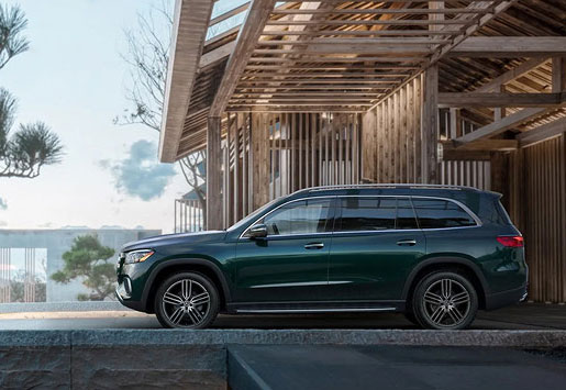 Mercedes-Benz EQS SUV parked outside modern luxury home showcasing elegant design