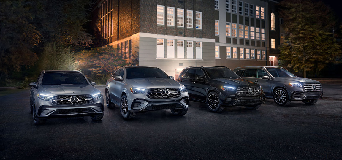 Mercedes-Benz SUV lineup parked at night in front of illuminated building