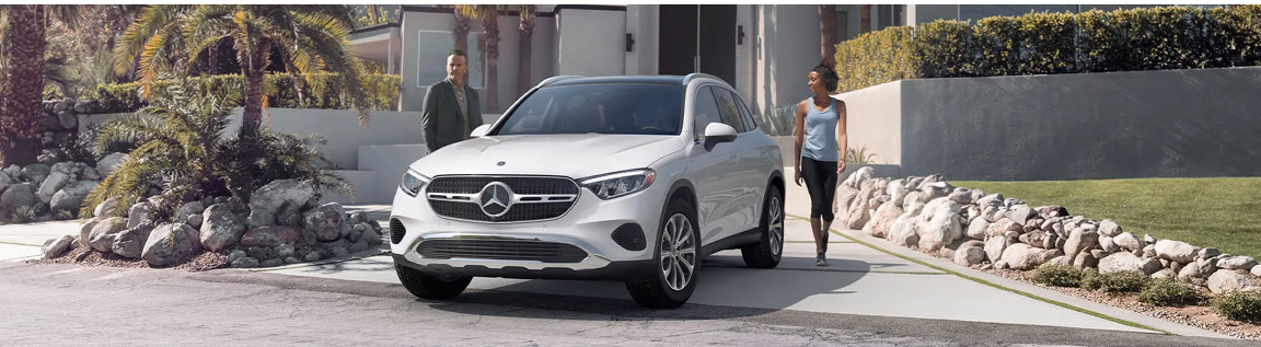 Mercedes-Benz GLC SUV parked in residential driveway with couple walking nearby
