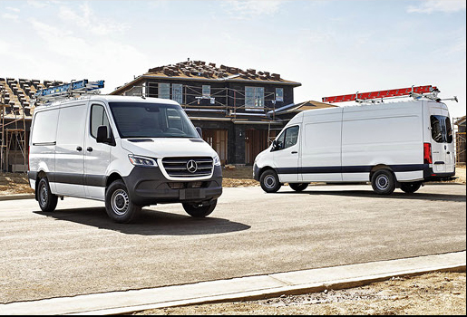 Two Mercedes-Benz Sprinter work vans with ladder racks at home construction project