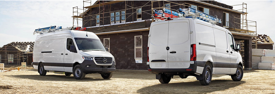 White Mercedes-Benz Sprinter cargo vans parked at construction development site