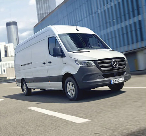Mercedes-Benz Sprinter cargo van driving in city with modern skyline background