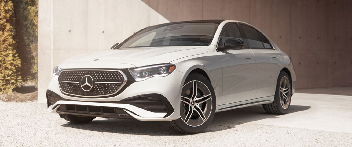 white Mercedes-Benz luxury sedan parked outside modern architectural building