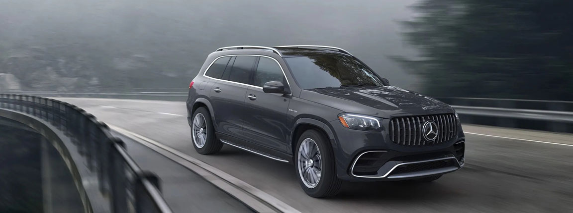 Mercedes-AMG GLS SUV driving on a winding highway showcasing dynamic performance, LED lighting and premium luxury design.