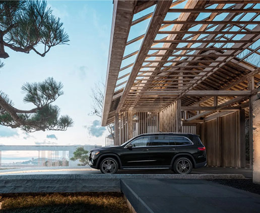 Mercedes-Benz GLS SUV parked beside a modern luxury waterfront home showcasing premium SUV styling and upscale lifestyle.