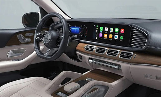 Mercedes-Benz GLS interior featuring the widescreen digital cockpit, MBUX infotainment system, Apple CarPlay, wood trim and premium luxury cabin.
