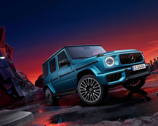 Mercedes-AMG G-Class SUV in a vibrant blue finish on a dramatic urban night backdrop showcasing high-performance luxury styling.