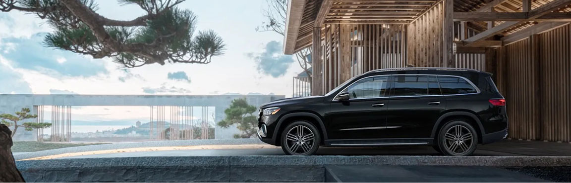Mercedes-Benz GLS SUV parked beside a modern luxury waterfront home showcasing premium SUV styling and upscale architectural design.