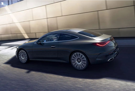 Mercedes-Benz CLA Coupe driving through an urban setting, highlighting sleek fastback styling, luxury design, and sporty performance