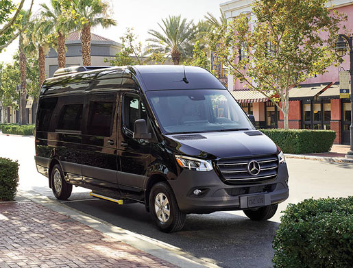Mercedes-Benz Sprinter passenger van parked in an urban setting, featuring spacious transportation, premium comfort, and shuttle versatility