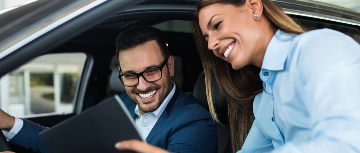 a sales rep showing information on a tablet to a client
