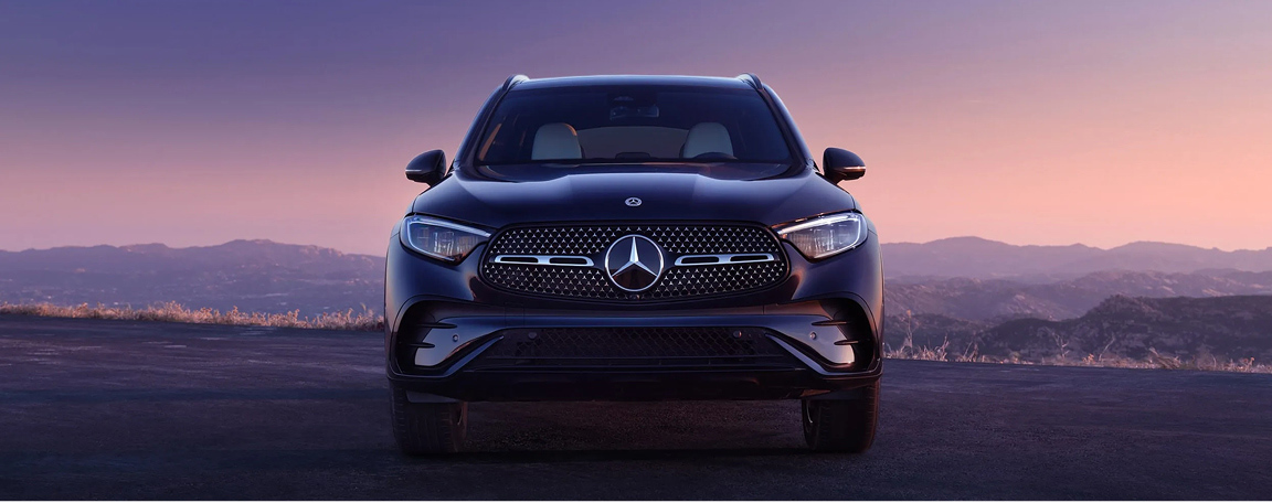 A Mercedes-Benz parked, behind it there is a mountain view