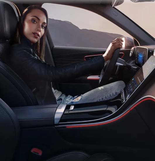 a lady inside of a Mercedes-Benz looking at the camera