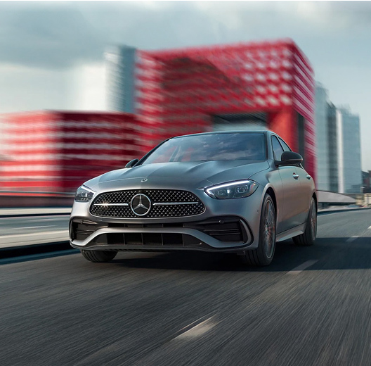 Mercedes-Benz vehicle driving on highway with blurred city background