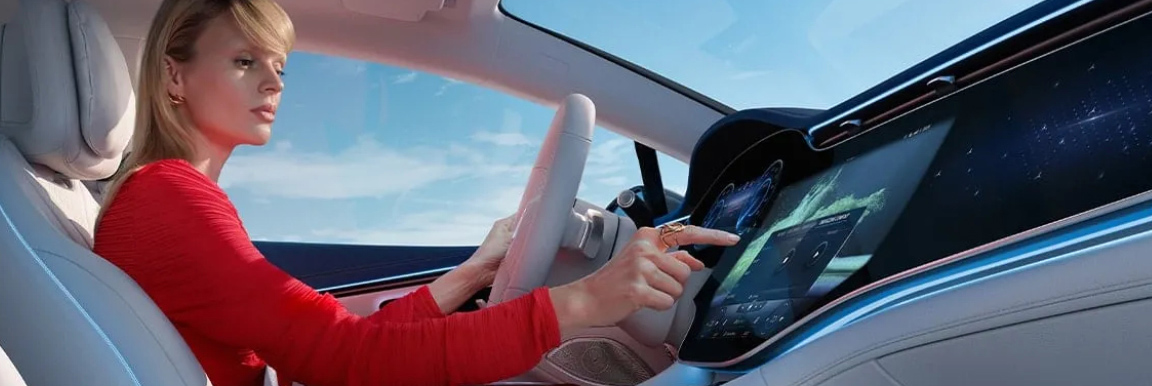 Woman interacting with Mercedes-Benz vehicle digital dashboard screen
