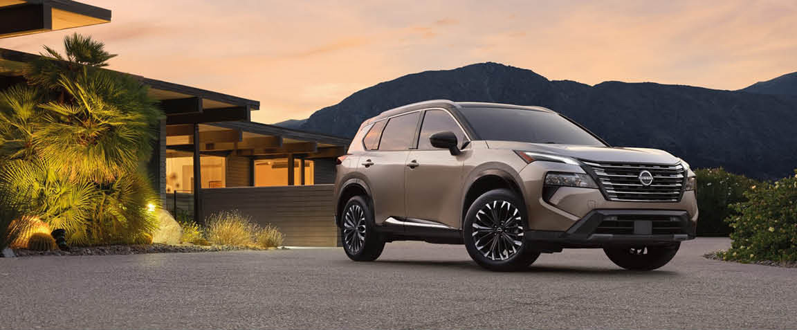Nissan Rogue SUV parked in front of a modern home at sunset