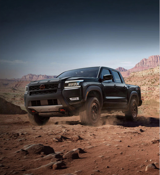 Black Nissan Frontier PRO-4X driving off-road through desert terrain