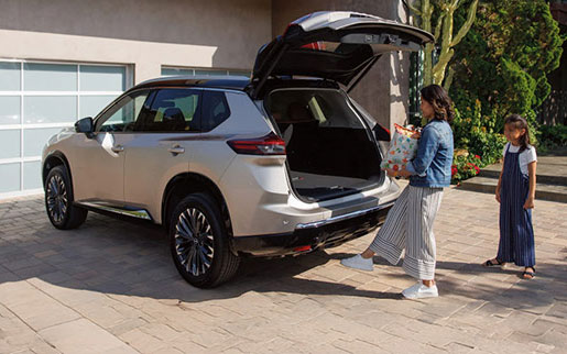 Nissan Rogue with hands-free power liftgate loading groceries at home driveway