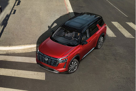 Red Nissan SUV driving through city intersection from overhead view