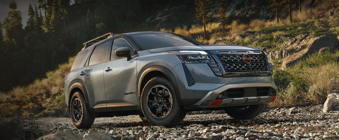Nissan Pathfinder Rock Creek SUV driving on rocky terrain in forest setting