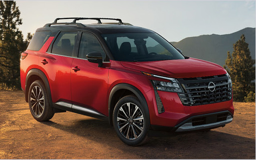 Red Nissan Pathfinder SUV parked on dirt road with mountain landscape