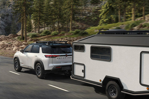 Nissan Pathfinder Rock Creek towing small camper trailer on scenic road