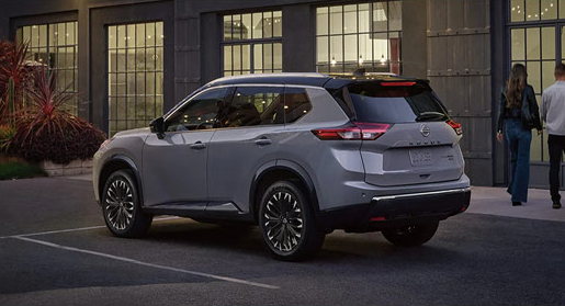 silver Nissan Rogue SUV parked outside a contemporary building in an urban setting