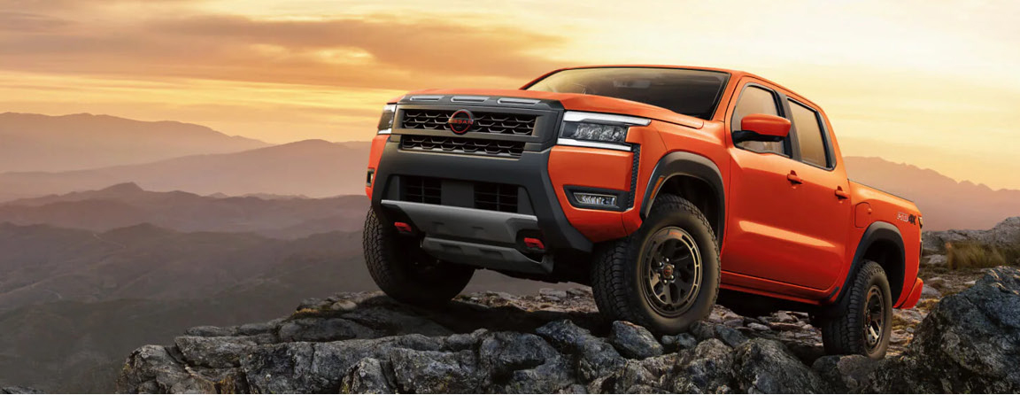Nissan Frontier PRO-4X parked on a mountain overlook showcasing bold styling, off-road equipment, and outdoor adventure capability
