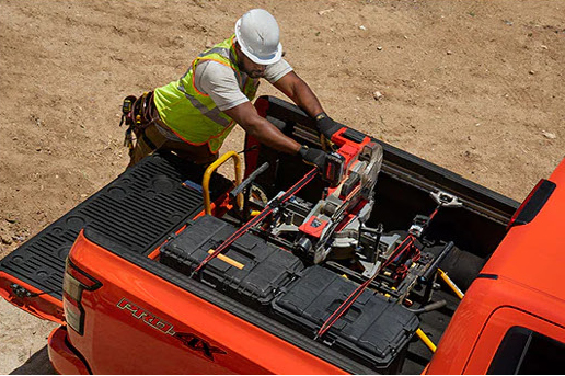 Nissan Frontier truck bed carrying professional equipment and tools, highlighting cargo management and work-focused practicality