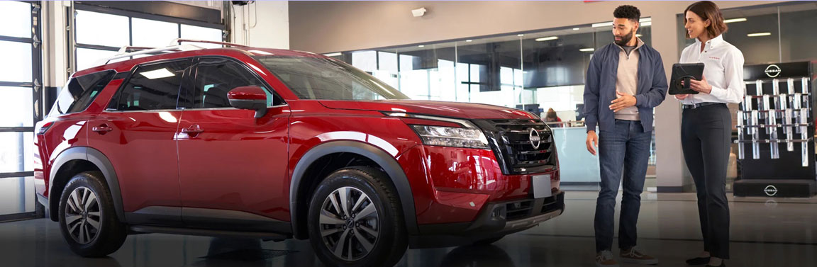 Nissan service advisor discussing vehicle maintenance with a customer
