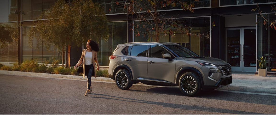Nissan Rogue SUV parked in urban setting with driver walking nearby