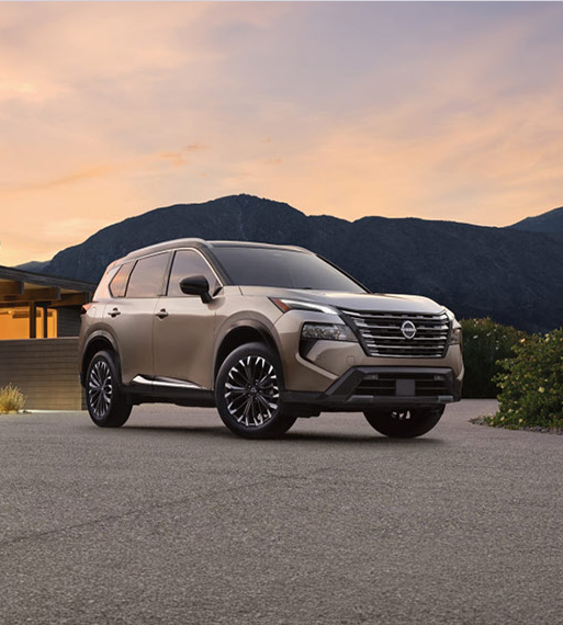 Nissan Rogue SUV parked outdoors at sunset with mountain background