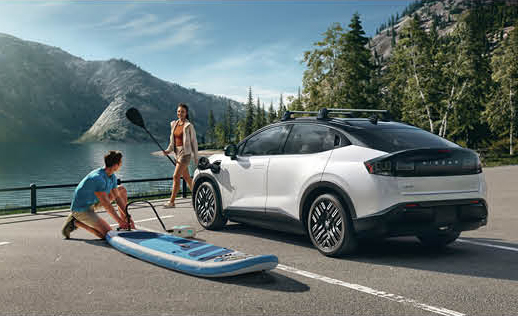 Nissan Ariya electric SUV parked near a lake with outdoor recreation gear