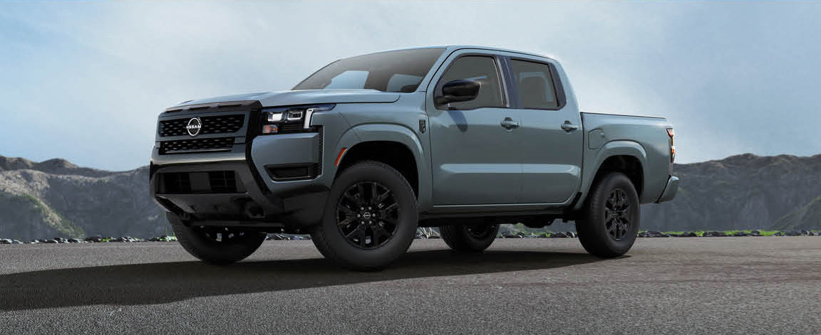 Nissan Frontier midsize pickup truck parked outdoors with mountain scenery