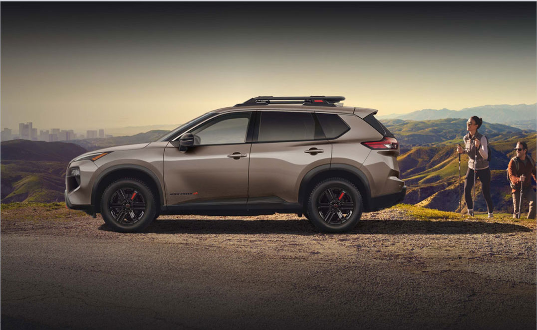 Nissan Rogue Rock Creek SUV parked on a mountain overlook with hikers nearby