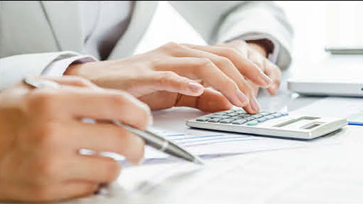 person using calculator reviewing car financing documents