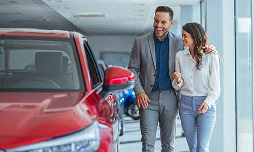 couple walking through car dealership showroom looking at vehicles