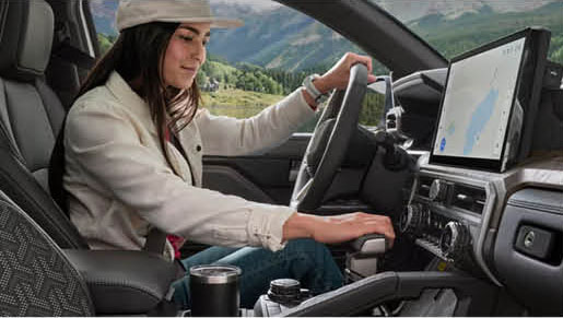 Toyota Tacoma interior with driver using center console and touchscreen infotainment system