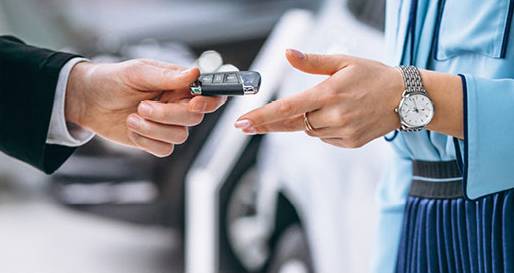 Customer receiving car keys from a dealership salesperson